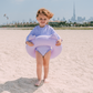 Kid on a beach wearing a swimming purple panther band 